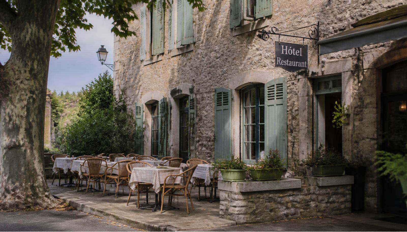 Terrasse de restaurant d'hôtel dressée au coucher du soleil, piscine en arrière-plan